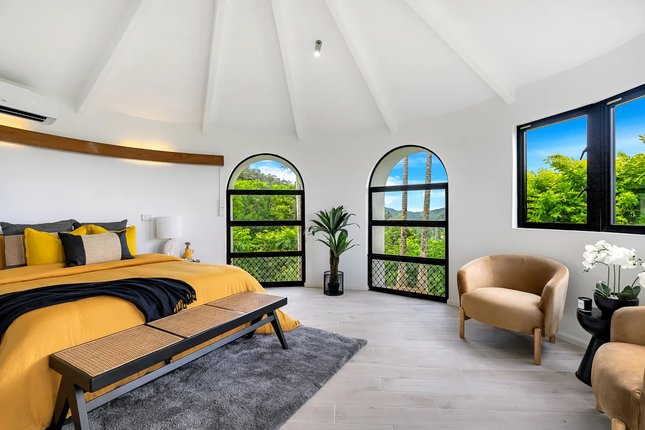 Stunning bedroom with arched windows and yellow bedding, professionally edited for Australian property listings.