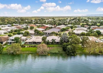 Cinematic waterfront residential property aerial photo enhanced for luxury real estate listing.