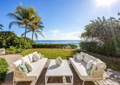 Outdoor patio with ocean views professionally edited with HDR blending for a clear horizon and vibrant lighting.