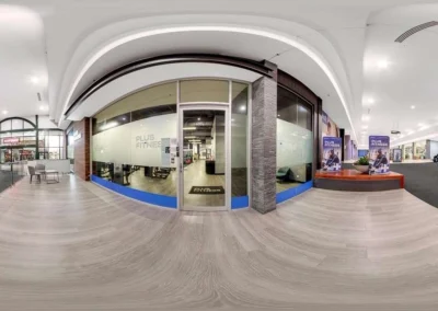 Stitched 360-degree view of a commercial property entrance and gym storefront for listing.