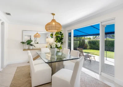 Bright dining room with a clear window view enhancement showing the outdoor patio and garden area.