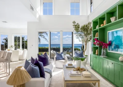 Luxury living room with high ceilings and a ocean view window pull to showcase the beach front view.
