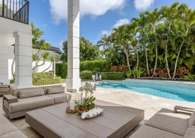 Bright poolside lounge area with blue sky replacement, and professional exposure correction.
